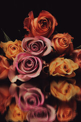 Beautiful Vintage Bouquet of roses and flowers with a filter over, used for love and passion and wedding bells. Shot on a reflective surface in a studio with a dark black background. 
