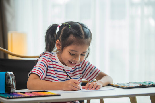 Little kid girl artist drawing coloring picture with paints and brushes. Child hobby creative art activity at home play alone.