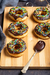 Homemade donuts on a wooden board on a grunge table. Close up - 611711356