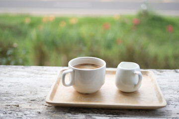 Coffee and milk on brown wooden tray outdoor relaxing drinking