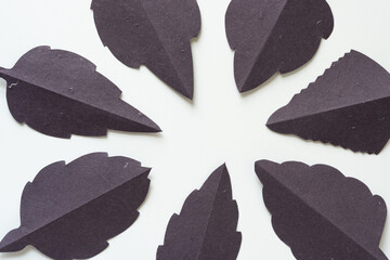 loosely gathered gray-purple-brown foliage-inspired patterns or shapes on blank paper