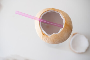 young coconut with open top, juice and tube