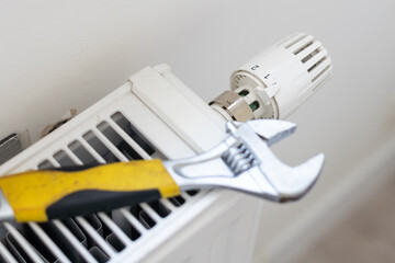 tightens the nut on the radiator with an adjustable wrench