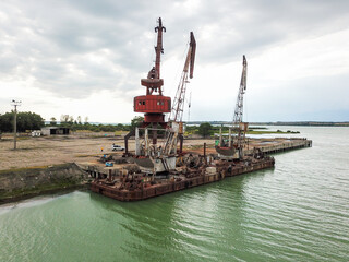 Abandoned port with rusted quay cranes