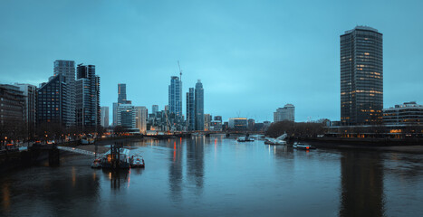 Panoramic view of London with the River Thames and skyscrapers in the lights before dawn. London, United Kingdom