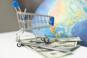 a planet earth in a supermarket shopping cart on blue background. copy space shopping trolley and toy ball in form of planet Earth © Angelov