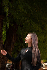 Bueaty girl brunet hair ware black dress with green forest background