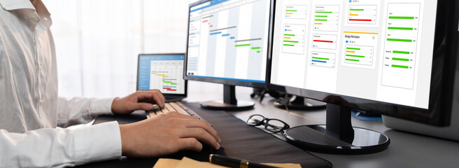 Project manager planning schedules for business task on office using gantt chart software display...