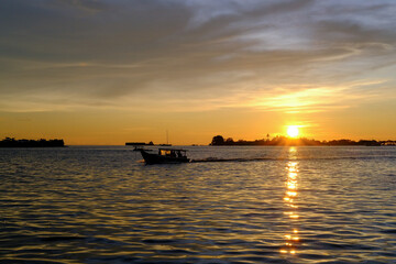 Fototapeta na wymiar sunset view from the pier in makassar city, sunset at the sea, sunset over the sea, sunset in the sea
