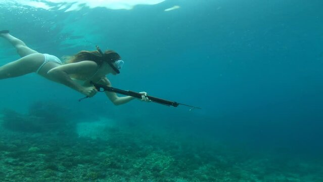 Snorkeling, spear gun and woman in ocean for fishing, hunting and catch fish on adventure, holiday and vacation. Diving, travel and female person in tropical water with harpoon swim for spearfishing