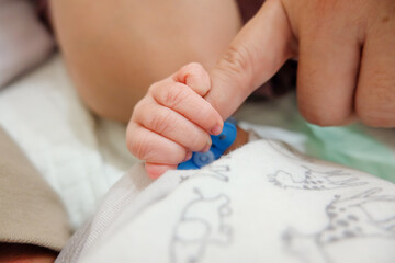 Obraz na płótnie Canvas newborn's hand holds mom's finger