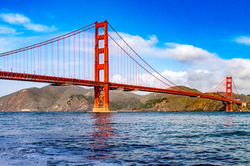 Golden Gate Bridge in the bay of the city of San Francisco, in the state of California in the USA, crossing the ocean under a blue sky and beautiful clouds. Concept America.