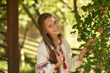 young woman sitting on a pier in a forest with a basket of fresh flowers 