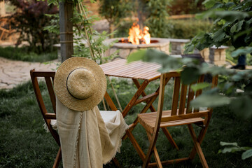 Wooden furniture in the garden against the backdrop of a fire on the patio.