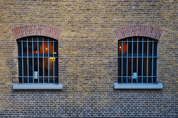Barred cell windows in the old brick wall of a 19th-century prison