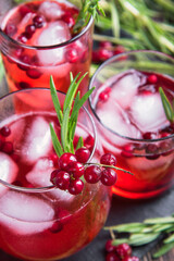 Glasses of currant juice with ice on a black stone board, close-up. View from above.