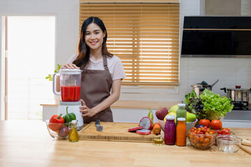 Woman making healthy smoothie using blender.