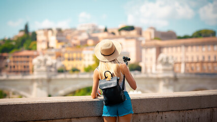 Young attractive smiling girl tourist exploring new city at summer