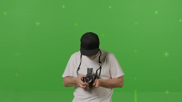 fashion photographer shooting with vintage film camera On Green Screen Background In The Studio