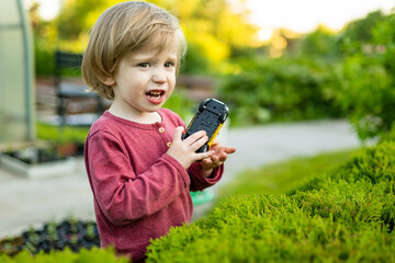 Adorable toddler boy having fun outdoors on sunny summer day. Child exploring nature. Summer activities for kids.