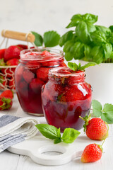 Strawberry basil jam in glass jars. Fragrant berry herb dessert. Selective focus