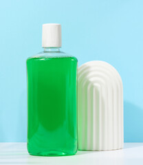 Refreshing mouthwash in a transparent plastic bottle  on a blue background