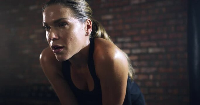 Tired, breathing or face of woman in gym for exercise workout for wellness with resilience or challenge. Fatigued girl, breathe or exhausted sports athlete resting or sweating in fitness center