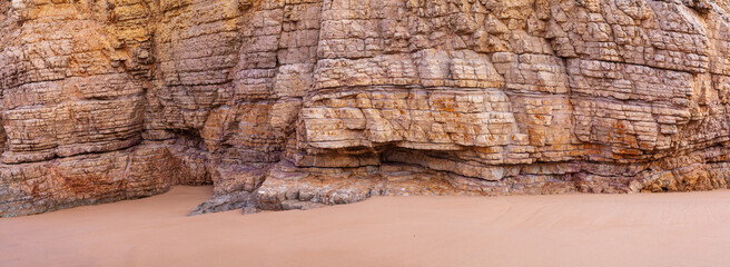 Close up in panorama format of the heavily eroded limestone cliffs at Beliche beach (Praia do...