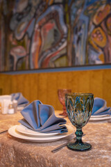 table setting in the restaurant for evening guests. white dishes , napkins and a glass with appliances on the table