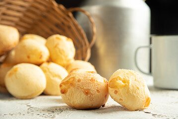 Cheese bread, Basket with cheese bread lying on a white lace tablecloth and accessories, dark background, selective focus.