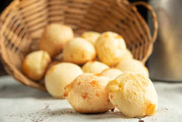 Cheese bread, Basket with cheese bread lying on a white lace tablecloth and accessories, dark background, selective focus.