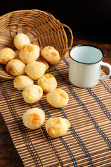 Cheese bread, Basket with cheese bread lying on a wooden woven mat and accessories, dark...