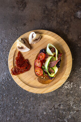 top view bread bruschetta with tomato and cucumber on a wooden plate