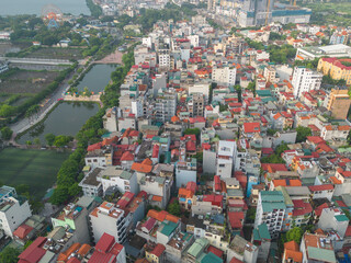 Fototapeta na wymiar Aerial view of residential neighborhood roofs. Urban housing development from above. Top view. Real estate in Hanoi City, Vietnam. Property real estate.