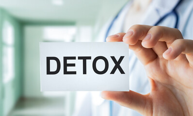 Woman holding card with word DETOX. Woman health. Cut out part of body. Medical problem and...