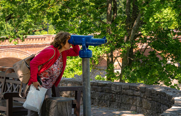Woman looking in to binocular viewer. Tourist concept