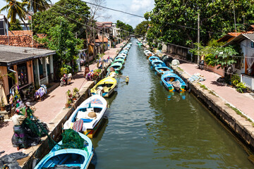 Fototapeta na wymiar Old canal with houses and small fishing boats in Negombo, Sri Lanka, Asia