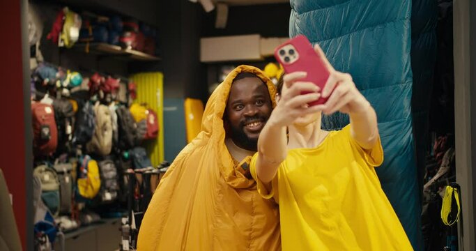 Laughter and Playfulness: Black Guy and European Girl's Memorable Selfie Session in a Hiking Gear Store