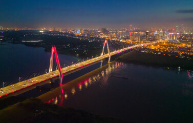 Fototapeta na wymiar Aerial view of Cau Nhat Tan Cable Bridge or Vietnam–Japan Friendship Bridge crossing the Red River in Hanoi City, Vietnam. Tourist attraction landmark.