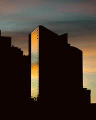 A silhouette of skyscrapers against a sunset backdrop