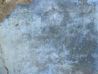 Old paint on cement surface. grey, blue and brown color. textured surface. old cement wall close-up. dirty blue background. dirty plaster with stains. location shooting. wall abandoned house