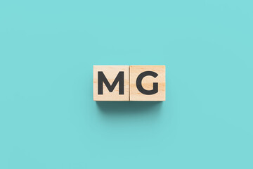 MG (Myasthenia Gravis) wooden cubes on teal background