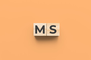 MS (multiple sclerosis) wooden cubes on orange background