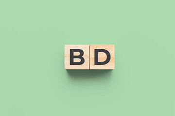 BD (Bipolar Disorder) wooden cubes on green background