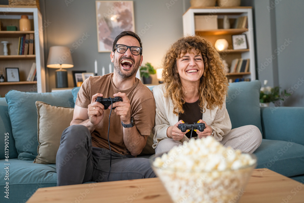 Wall mural couple man and woman husband wife play console video games at home