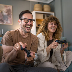 couple man and woman husband wife play console video games at home © Miljan Živković