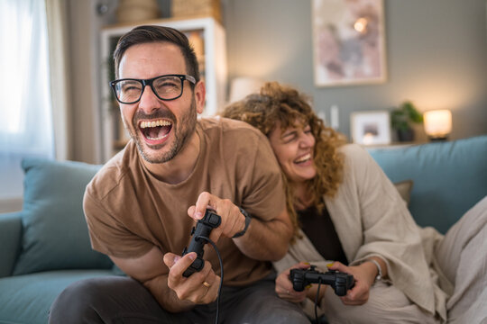 couple man and woman husband wife play console video games at home