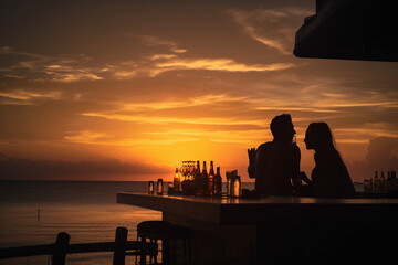 Sunset on the beach. A couple enjoying a romantic drink at the bar counter, silhouetted against the sky. Relaxation and holiday vibes. .