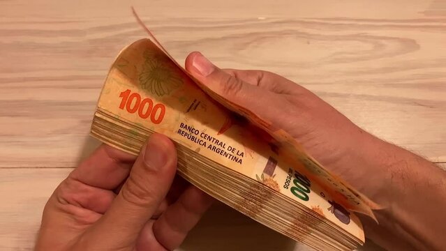 slow motion of hands counting money Argentine 1000 peso bills, symbol for Argentina's inflation