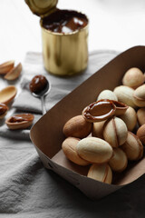 Delicious walnut shaped cookies with condensed milk on table, closeup